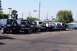 1990 Ford Bronco - Multiple Ford Bronco SUVs are parked in a lot under a clear sky.