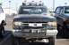 1990 Ford Bronco - Front view of a muddy 1990 Ford Bronco with auxiliary lights and a winch.