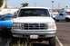 1990 Ford Bronco - Front view of a white Ford Bronco parked in a lot with another truck visible.