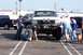 1990 Ford Bronco - Several people examine a heavily modified Ford F-Series truck with oversized tires and a winch.