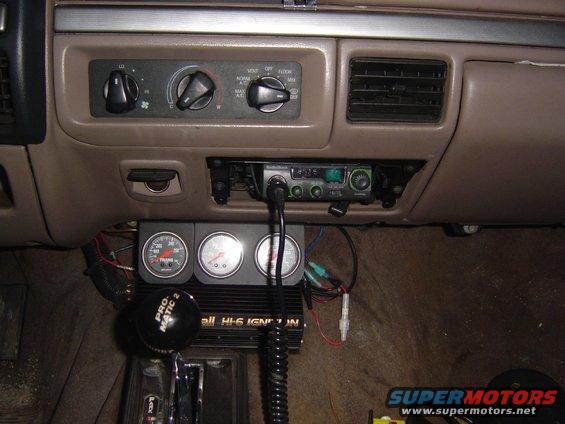 Interior dashboard with CB radio and three gauges, including a tachometer