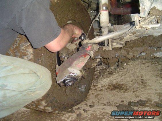 1993 Ford Bronco front suspension and tire covered in mud