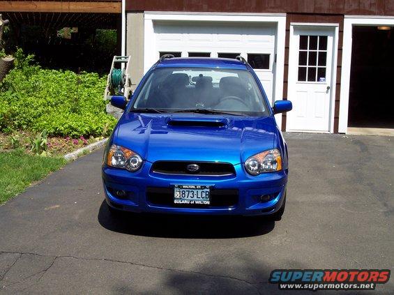 Blue Subaru Impreza WRX parked in driveway in front of garage