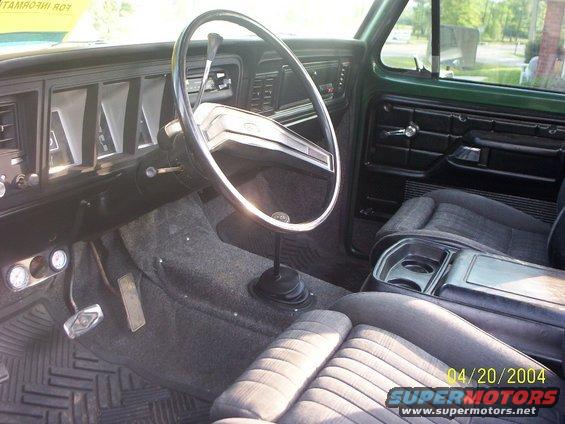 Green 1978 Ford Bronco interior, showing dashboard, steering wheel, seats, and floor shifter