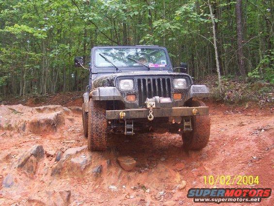 Black 1994 Jeep YJ on rocky, muddy trail