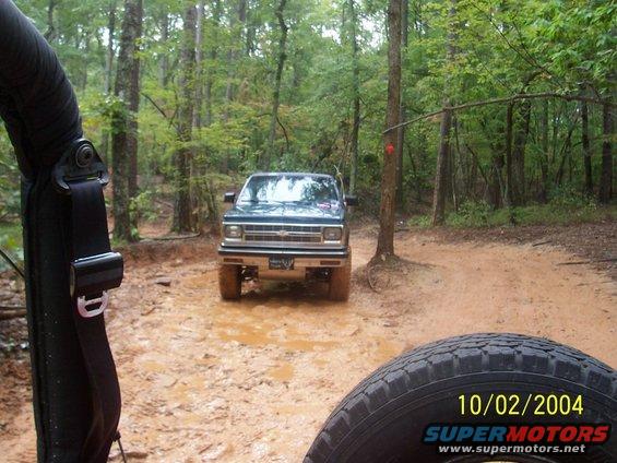 Green pickup truck on muddy trail, front view. Dated 10/02/2004