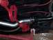 1963 Ford Fairlane - Close-up of the undercarriage showing red painted suspension components and a silver exhaust pipe.
