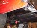 1963 Ford Fairlane - Underside view of a red vehicle, highlighting the fuel tank, exhaust system, and rear axle components.