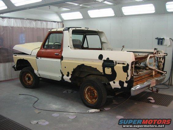 1978 Ford Bronco in paint booth, primer showing through peeling paint