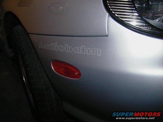 Silver car fender with red side marker and 'Audiobahn' badge