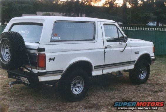 White 1990 Ford Bronco with a spare tire mounted on the rear, 4x4 decal on the side, and ORU stickers on the windows