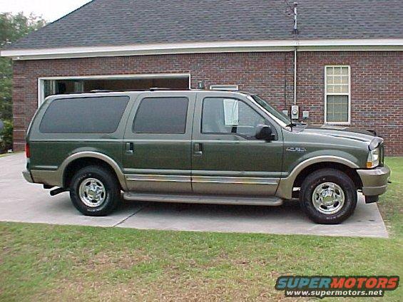 Green 2003 Ford Excursion parked on concrete driveway in front of brick house