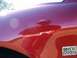 2000 Ford Taurus - A close-up of a red car's fender shows a reflection of a person holding a camera and a '24V DOHC' badge.