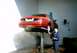 2000 Ford Crown Victoria - A mechanic washes the rear of a red 2000 Ford Crown Victoria on a car lift.