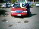 2000 Ford Crown Victoria - A red 2000 Ford Crown Victoria is being washed in a parking lot, with another white car visible in the background.