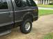 1995 Ford Bronco - Rear side view of a dark gray pickup truck with a camper shell and FX4 Off Road decal.