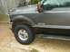 1995 Ford Bronco - Front quarter panel and door of a gray Ford F-250 Super Duty, showing the F-250 badge and side step.