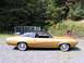 1970 Mercury Cougar - Side profile of a gold 1970 Mercury Cougar with a black vinyl top, parked outdoors.