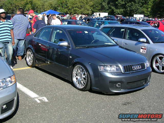 Dark gray Audi sedan with custom wheels parked at an outdoor event