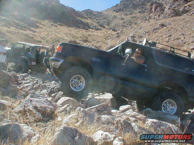 Black 1987 Ford Bronco climbing rocks