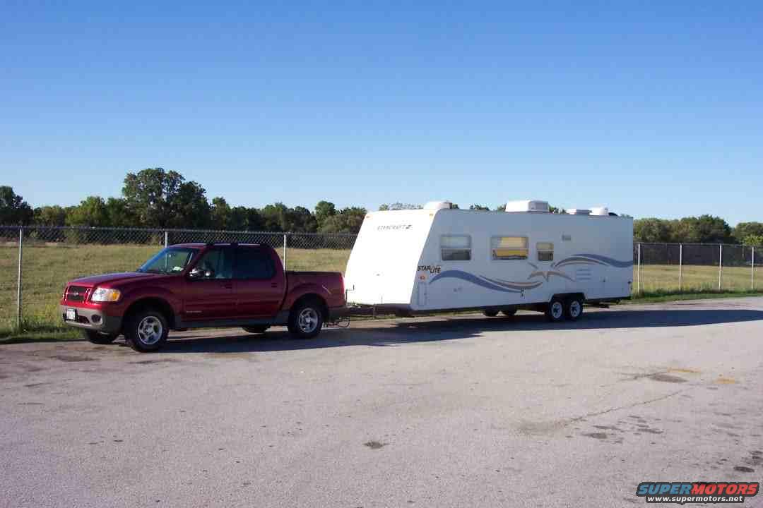 Red 2002 Ford Sport Trac towing a white travel trailer