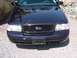 1999 Ford Crown Victoria - Front view of a dark blue 1999 Ford Crown Victoria, highlighting its distinctive honeycomb grille and Ford emblem.