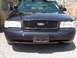 1999 Ford Crown Victoria - This Ford Crown Victoria features a honeycomb grille and aftermarket headlights, suggesting a model year different from the claim.