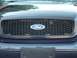1999 Ford Crown Victoria - The honeycomb grille and Ford oval badge are visible on this dark blue vehicle.
