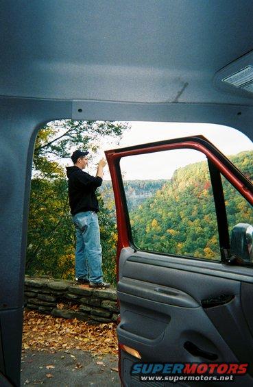 Red truck interior with open door showing person at scenic overlook