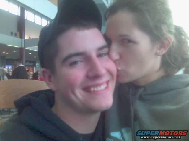 Couple in a mall, woman kissing man on cheek