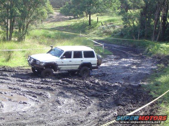 White off-road SUV stuck in mud with snorkel and spare tire