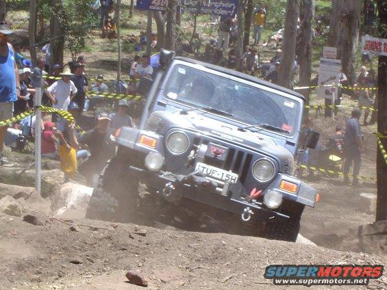 Blue Jeep Wrangler TJ navigating an off-road obstacle course