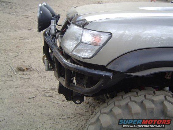 Off-road vehicle front end with large tires, auxiliary lights, and a custom bumper