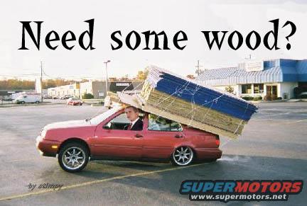 Red sedan carrying a large load of lumber