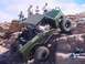 1988 Ford Bronco - An off-road vehicle navigates a rocky incline with several onlookers observing the challenging climb.