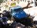 1988 Ford Bronco - A blue off-road vehicle is being winched through a difficult rocky terrain while onlookers observe.