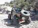 1988 Ford Bronco - Off-road SUV with extensive modifications navigates a rocky trail.