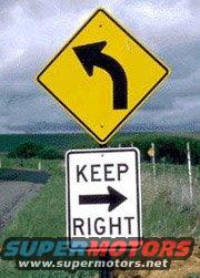 Yellow diamond sign with left arrow, white rectangular sign with 'KEEP RIGHT' and right arrow