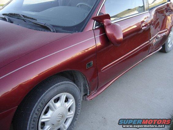 Red 1998 Mercury Sable sedan with significant damage to the rear passenger door and quarter panel, viewed from the front passenger side