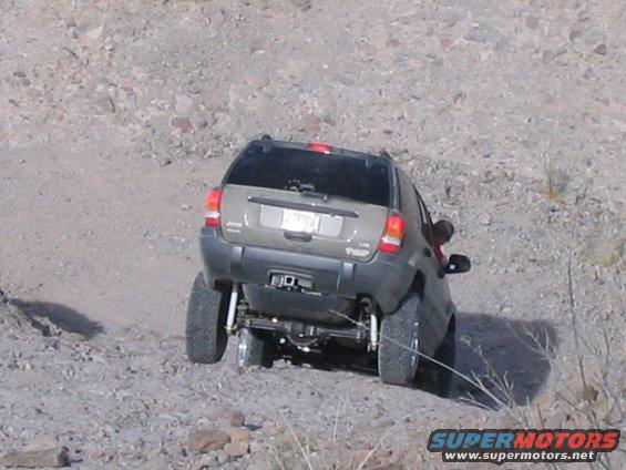 Jeep Grand Cherokee on a dirt trail, rear view. Lifted suspension