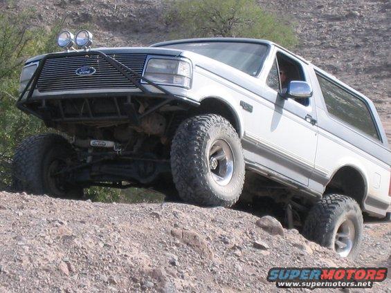 White Ford Bronco with off-road modifications on rocky terrain