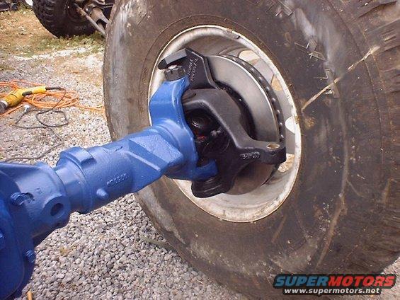 Blue painted front axle assembly connected to a large tire and brake system