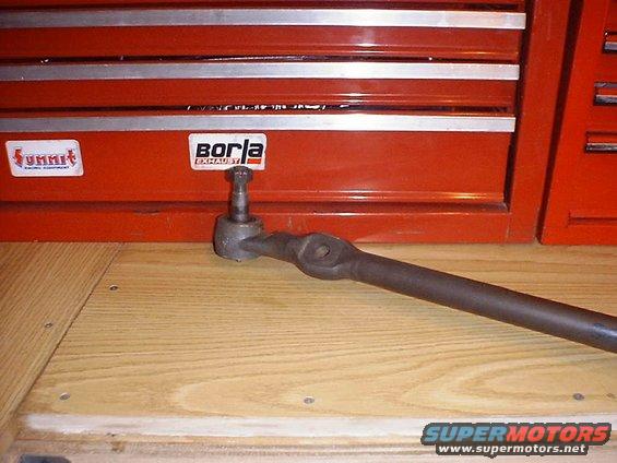 Tie rod end with Borla and Summit Racing Equipment stickers on a red toolbox