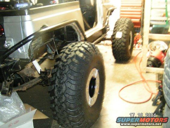 Off-road vehicle body with large tires, viewed from the side, in a garage