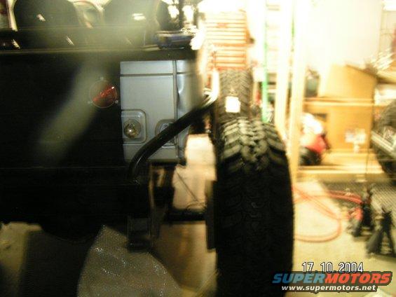 Rear corner of a vehicle with a spare tire mounted. Date stamp reads 17.10.2004