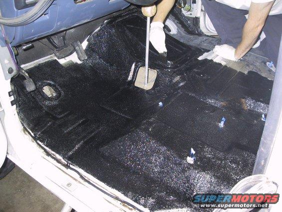 Applying black coating to the floor of a vehicle, covering the transmission tunnel and footwells