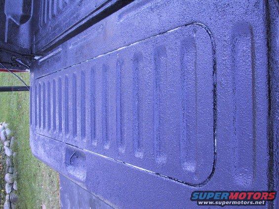 Purple truck bed liner with ribbed texture and a cutout