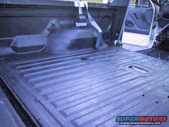 1993 Ford Bronco truck bed interior with spray-on liner and seatbelt