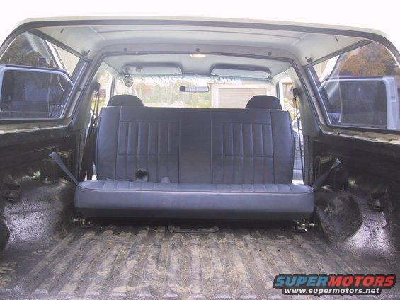 Rear bench seat in a cargo area with ribbed floor and black interior panels