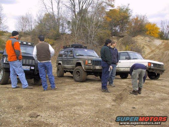 Three off-road vehicles and four men on a dirt road